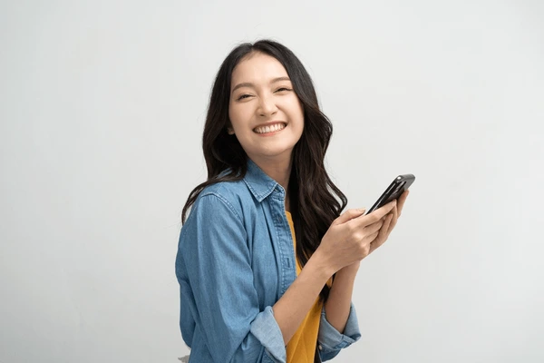 happy-asian-woman-holding-smartphone-600nw-2198262159